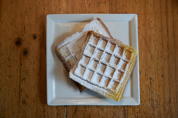 waffles in top view on a square plate on a wooden table