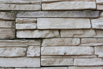 Stone surface gray colored with mottled texture. Rocky wall texture background. Clay sandstone bricks