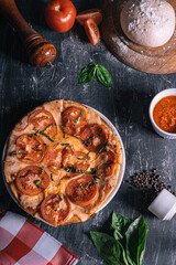 Delicious pepperoni pizza, a photo with a very nice background, where there are, pizza mace, pepper shaker, tomato split, bush leaves and little else.