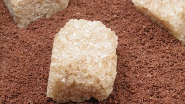 Ground coffee and lumpy cane sugar close-up. Coffee with sugar.