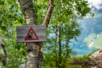 Urlaub in S&uuml;d-Norwegen: Warnschild Gefahr Absturz bei einer Wanderung zum Aussichtspunkt mit atembreaubenden Panorama-Blick auf den epische Geiranger Fjord