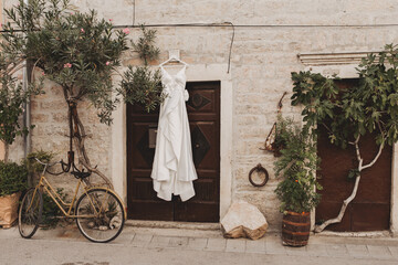 Wedding gown hanging from an old stone wall