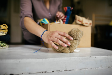 A Mother Putting Stuffed Toys In Cardboard Box