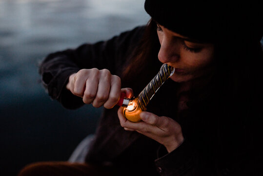 Woman smoking marijuana out of a pipe