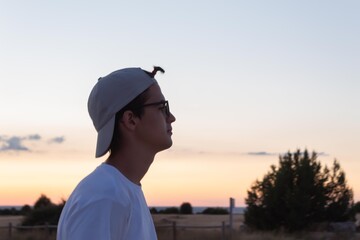 young man with a small ponytail on his forehead and a cap for the sun