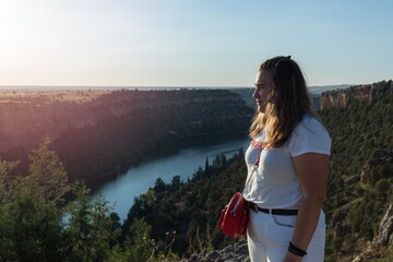 Teenager observing the grandeur of nature in the Rio Duraton Sickles National Park in Segovia Spain