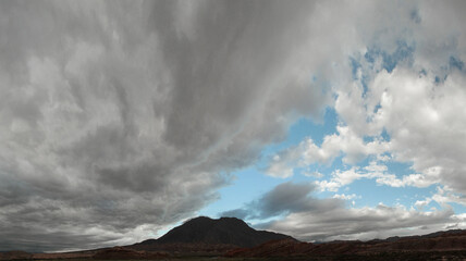 Volcanic landscape. Cloudscape. View of the volcano, mountains and valley under a dramatic sky with beautiful clouds.