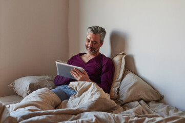 Man using a tablet in bed