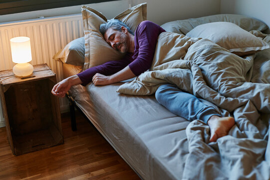Mature man sleeping in his bed