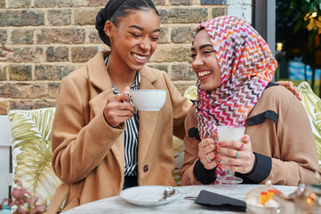 Young Muslim friends laughing over coffee