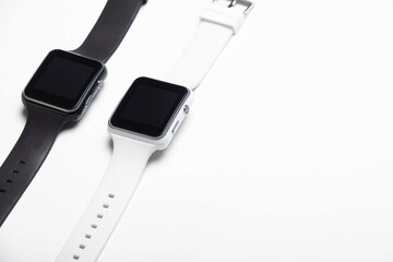 Electronic wrist watch on a white background . White and black wrist watches. Women's and men's watches. Isolated background. Article about modern watches. Article about choosing a watch.