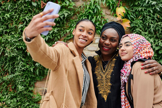 Muslim friends taking selfies in a park