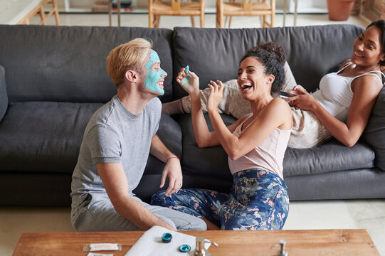 Laughing woman giving a man a facial