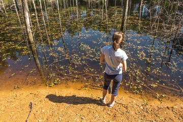 A young woman watching the old workings of the "Pasieki" iron mine flooded with water