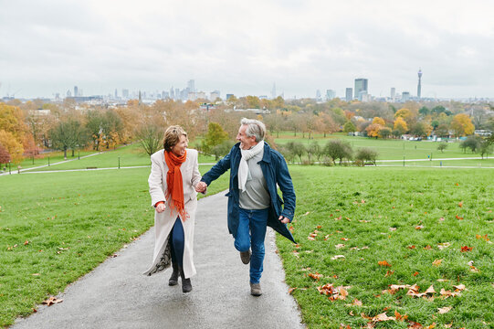 Laughing couple running in a park