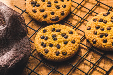 Delicious Fresh Chocolate Chip Cookies with chocolate on a Cooling Rack on wooden background, Close up