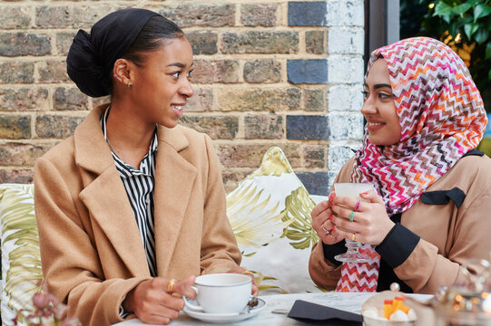 Young Muslim friends talking at a cafe