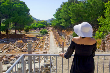 Beautiful young woman in black dress in Ephesus ancient city	