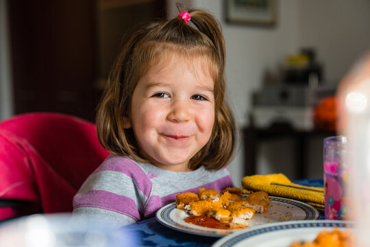 Funny girl having nuggets for lunch