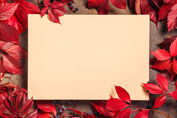 Frame with autumn leaves and an empty sheet for text on a stone background. Concept of fall season.