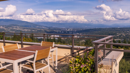 Fototapeta na wymiar Newly re-stained patio table on rooftop garden overlooking Burrard Inlet at Port Moody BC with valley and mountain backdrop - Fall