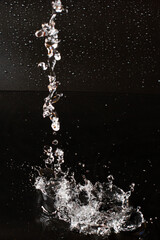 Fototapeta premium Splash of clear water on black isolated background.