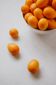 Kumquats on light background