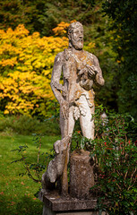 Fototapeta na wymiar Stone statue of a shepherd with dog in the park 