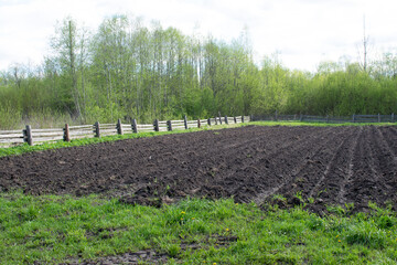 Fototapeta na wymiar Black plowed land, a place for planting vegetables