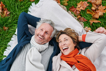 Laughing mature couple lying on grass