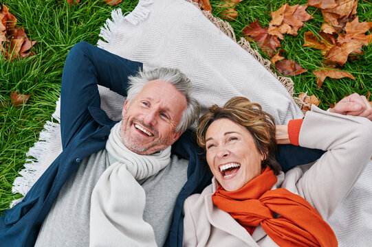 Laughing mature couple lying on grass