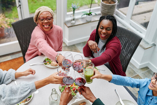 Laughing family toasting over dinner