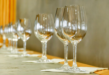Empty wine glasses stand in a row on the table. Ready for wine tasting.