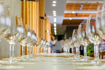 Empty wine glasses stand in a row on the table. Ready for wine tasting.