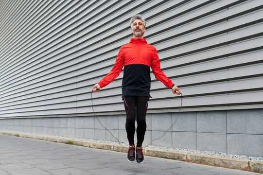 Fit man jumping rope on a sidewalk