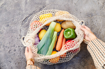 Woman opening a bag of fresh vegetables