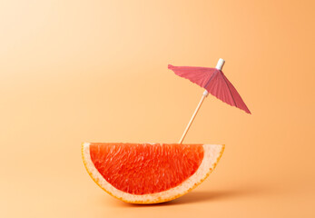 Grapefruit slice on a orange background. Summer, vacation and travel minimal concept.