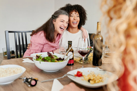 Friends laughing during a dinner party