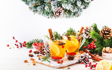 Winter hot tea with cranberry, lemon and spices in glass cup in Christmas or New Year's table...