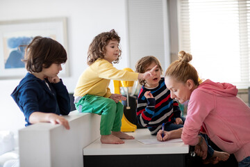 Young woman creating a shopping list for grocery with some suggestions from her kids...