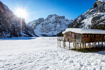 Beautiful, panoramic view to the snow covered lake Lago Di Braies, Pragser Wildsee, in the Italian Dolomites during a cold winter morning