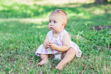 adorable baby in multicolored dress in the park