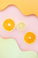 Halved lemons and oranges on vibrant colored wave backgrounds. Paper art style on photo. Concept of citrus, vitamin C, fruit.