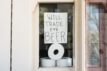 Covid-19 window sign about trading toilet paper for beer