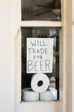 Covid-19 window sign about trading toilet paper for beer