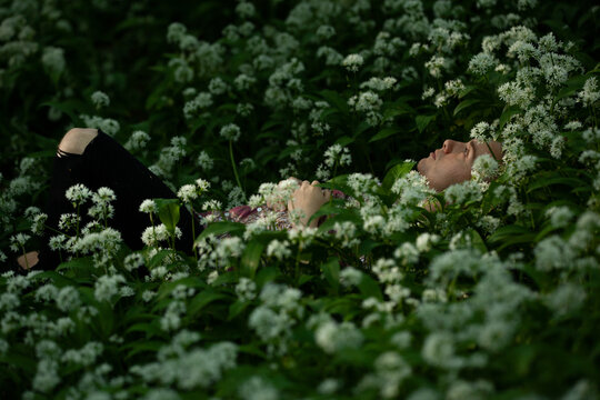 Young man lies in wild garlic