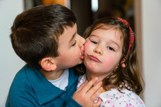Boy kissing sister in cheek