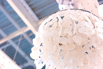 chandelier made of round mother-of-pearl plates suspended one after the other.