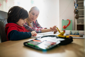 Mother help his nine year old son with his homework