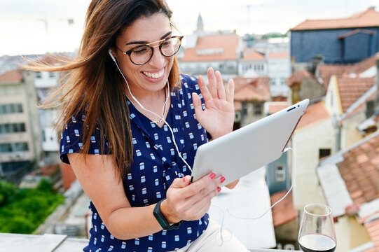 Smiling woman waving to friends during a video call